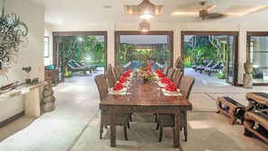 A spacious dining area with a long wooden table set for a meal, surrounded by wicker chairs. - Villa Avalon I by Elite Havens (Kabupaten Badung)