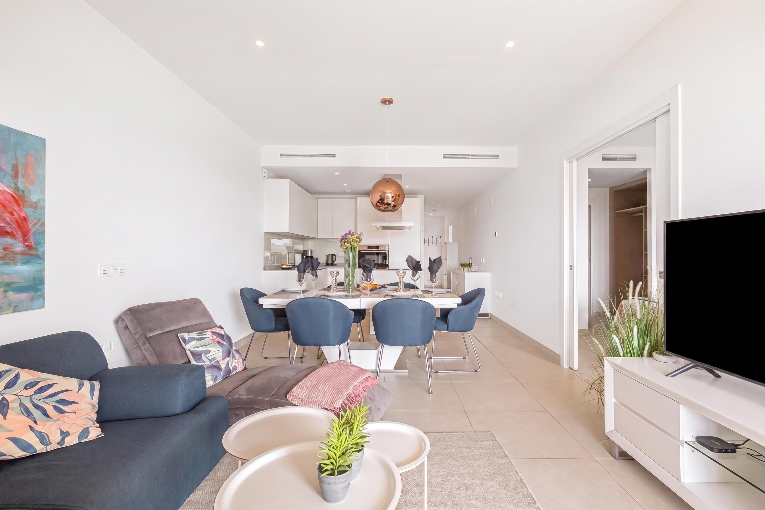 Un salon moderne avec un canapé, une table basse et un meuble pour la télévision.