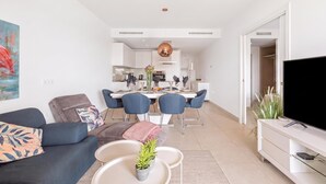 A modern living room with a sofa, a coffee table, and a TV stand. - Lotus Jardinana Paradise (Mijas)