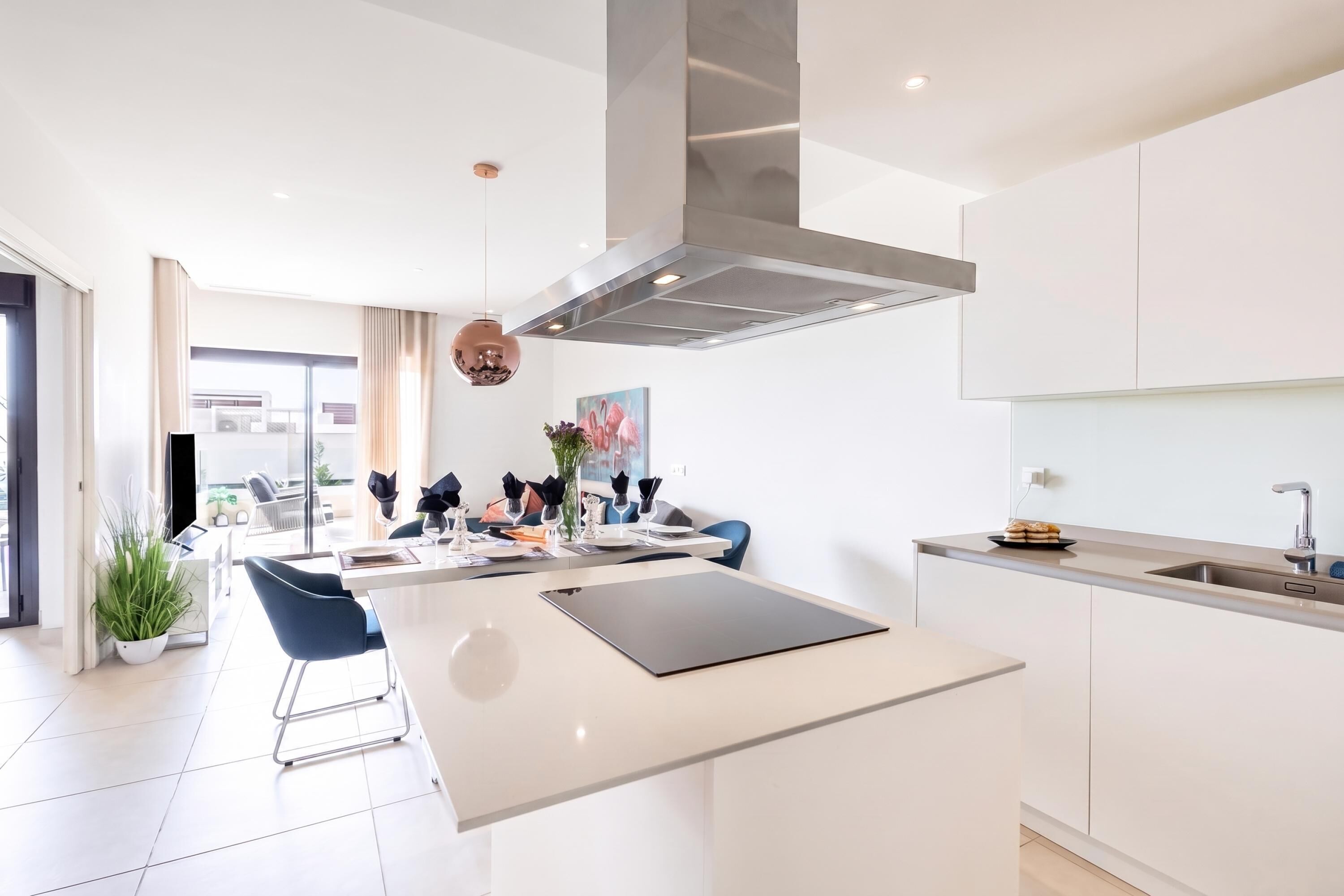 A modern kitchen with a central island, stainless steel appliances, and a view to the living area.