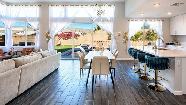 A modern kitchen with a dining area, large windows, and a view of the outdoors. - @ Marbella Lane - Desert Dream • Pool/Spa & Games (Desert Hot Springs)