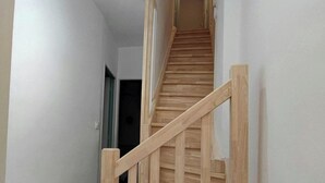 A wooden staircase with a handrail leading to an upper floor. - Ravissante New 3 chambres à Roubaix (Roubaix)