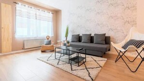 A modern living room with a sofa, coffee table, and a chair. - Ravissante New 3 chambres à Roubaix (Roubaix)