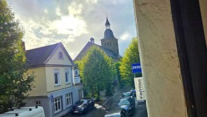 Una veduta di una strada con il campanile di una chiesa, auto parcheggiate e un edificio con un cartello che riporta la scritta 'St. Mary's'.