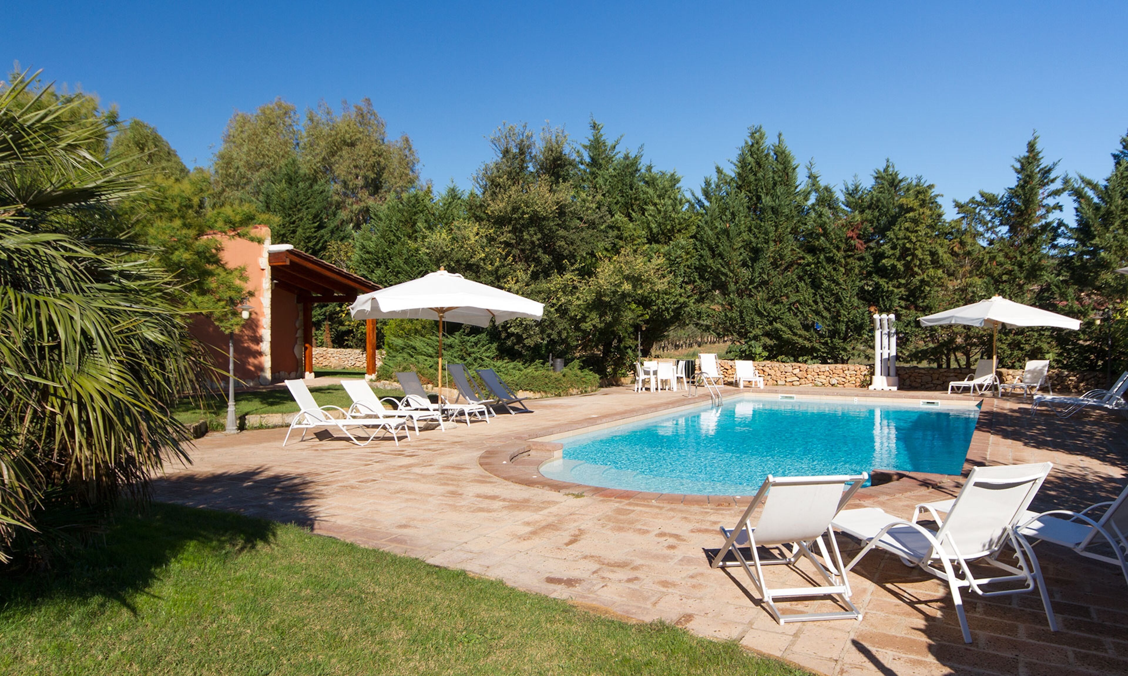 Een seizoensgebonden buitenzwembad, parasols voor strand/zwembad
