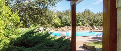 Una piscina al aire libre de temporada, sombrillas