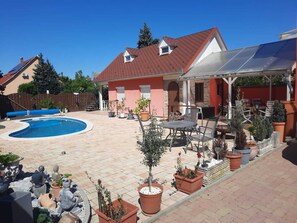 A backyard with a swimming pool, patio furniture, and potted plants. - Dog-friendly vacation apartment at Lake Balaton/Balatonboglar for 4 persons (Balatonboglár)