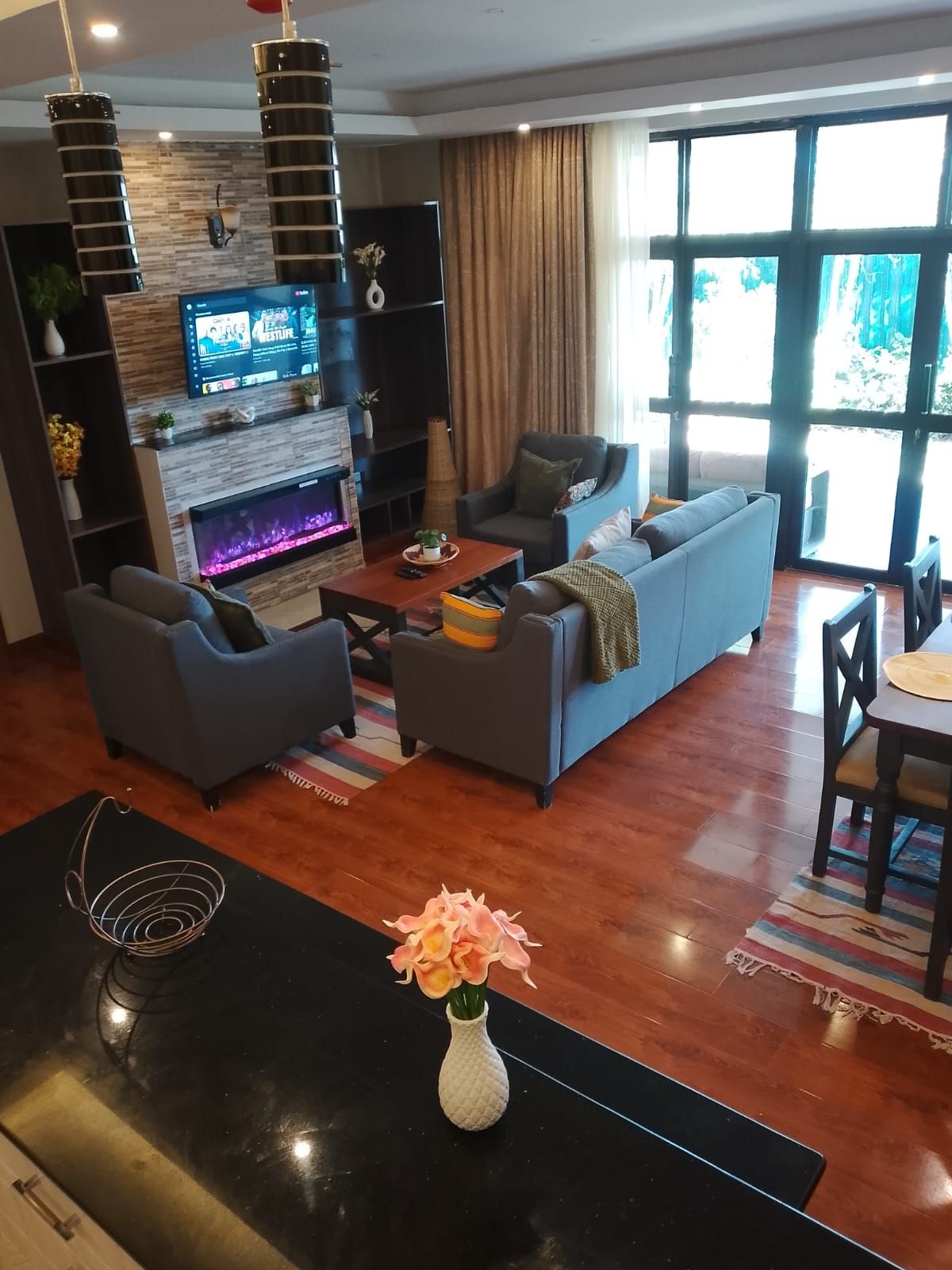 A modern living room with a fireplace, sofa, and television.