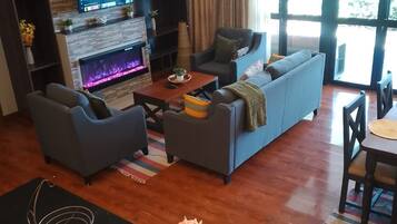 A modern living room with a fireplace, sofa, and television.