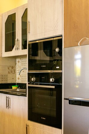 Une cuisine équipée d’un four Bosch, d’un four à micro-ondes et d’un réfrigérateur.