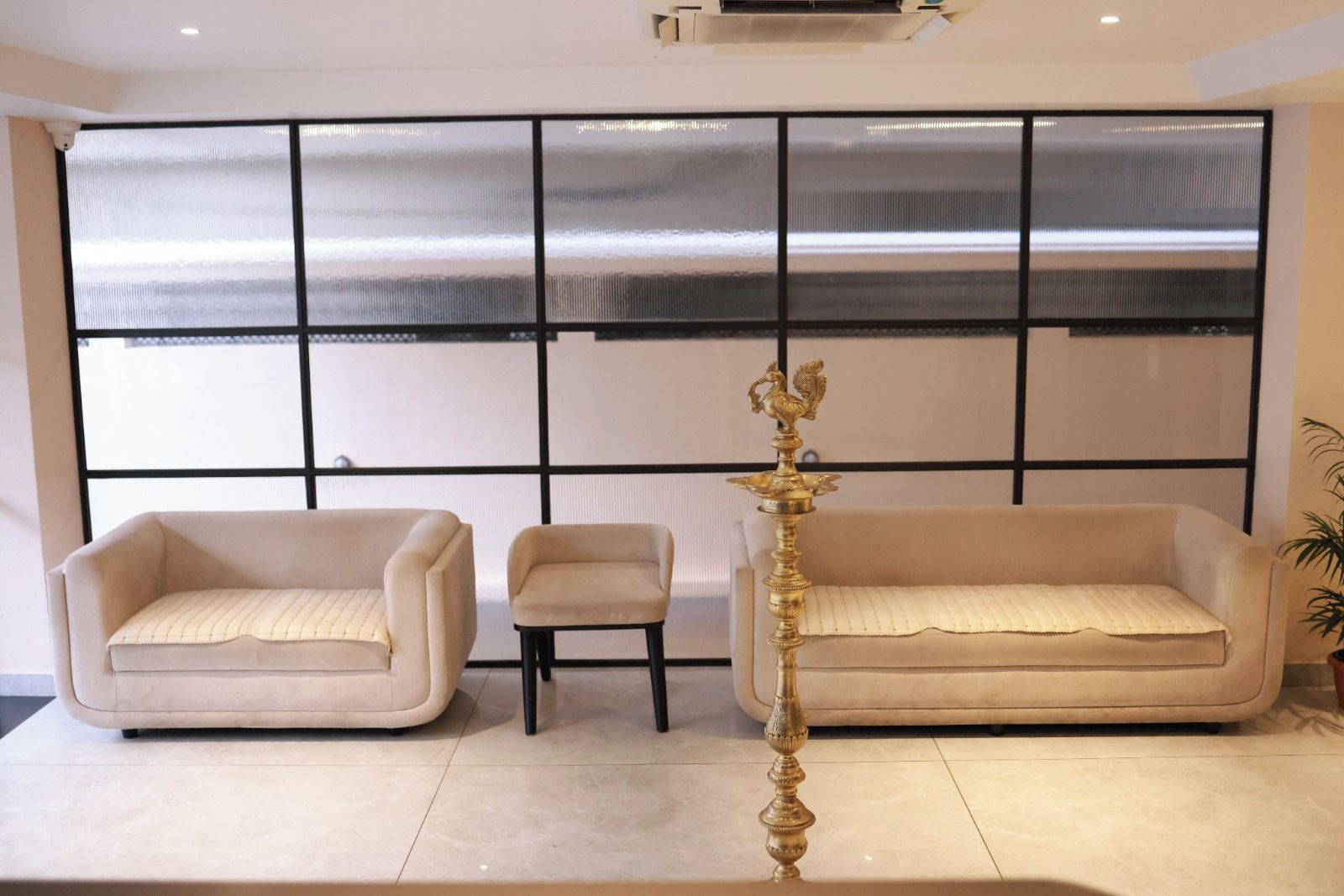 A room with a large window, two sofas, a small table, and a decorative lamp.