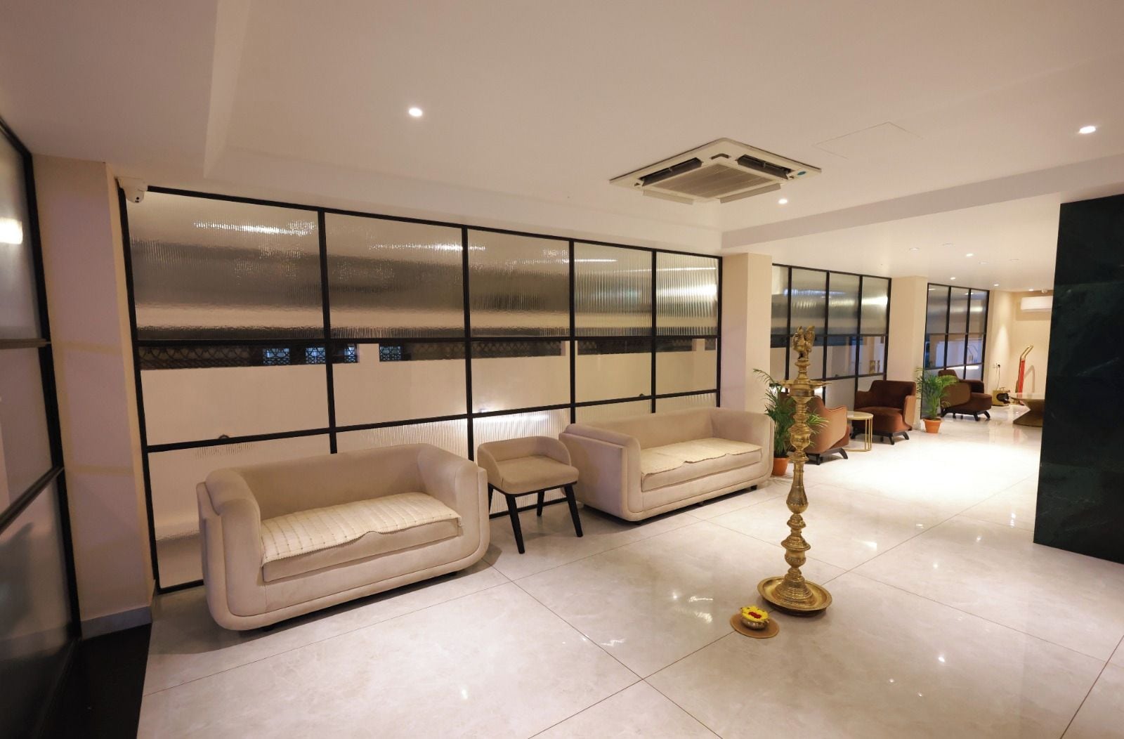 A modern lobby with a seating area, a decorative fountain, and a large window with a view.