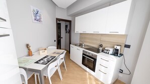 A compact kitchen with white cabinets, a built-in oven, and a coffee machine. - House le Treemme - Corigliano Rossano (Corigliano Scalo)
