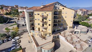 A multi-story hotel with balconies, a parking area, and a central courtyard. - House le Treemme - Corigliano Rossano (Corigliano Scalo)