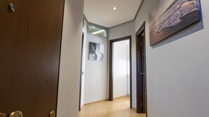 A hallway with wooden flooring, a door on the left, and a painting on the right wall. - House le Treemme - Corigliano Rossano (Corigliano Scalo)