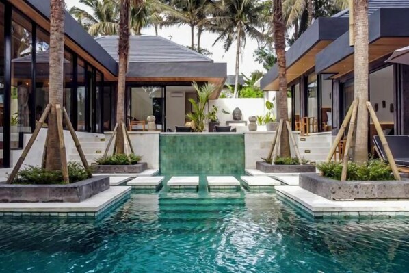 A modern pool area with clear water, surrounded by palm trees and contemporary architecture. - Villa Maya Bay by BaliSuperHost (Bali)