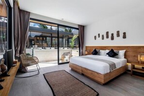 A modern bedroom with a large bed, a TV, and a view of the outdoors. - Villa Maya Bay by BaliSuperHost (Bali)
