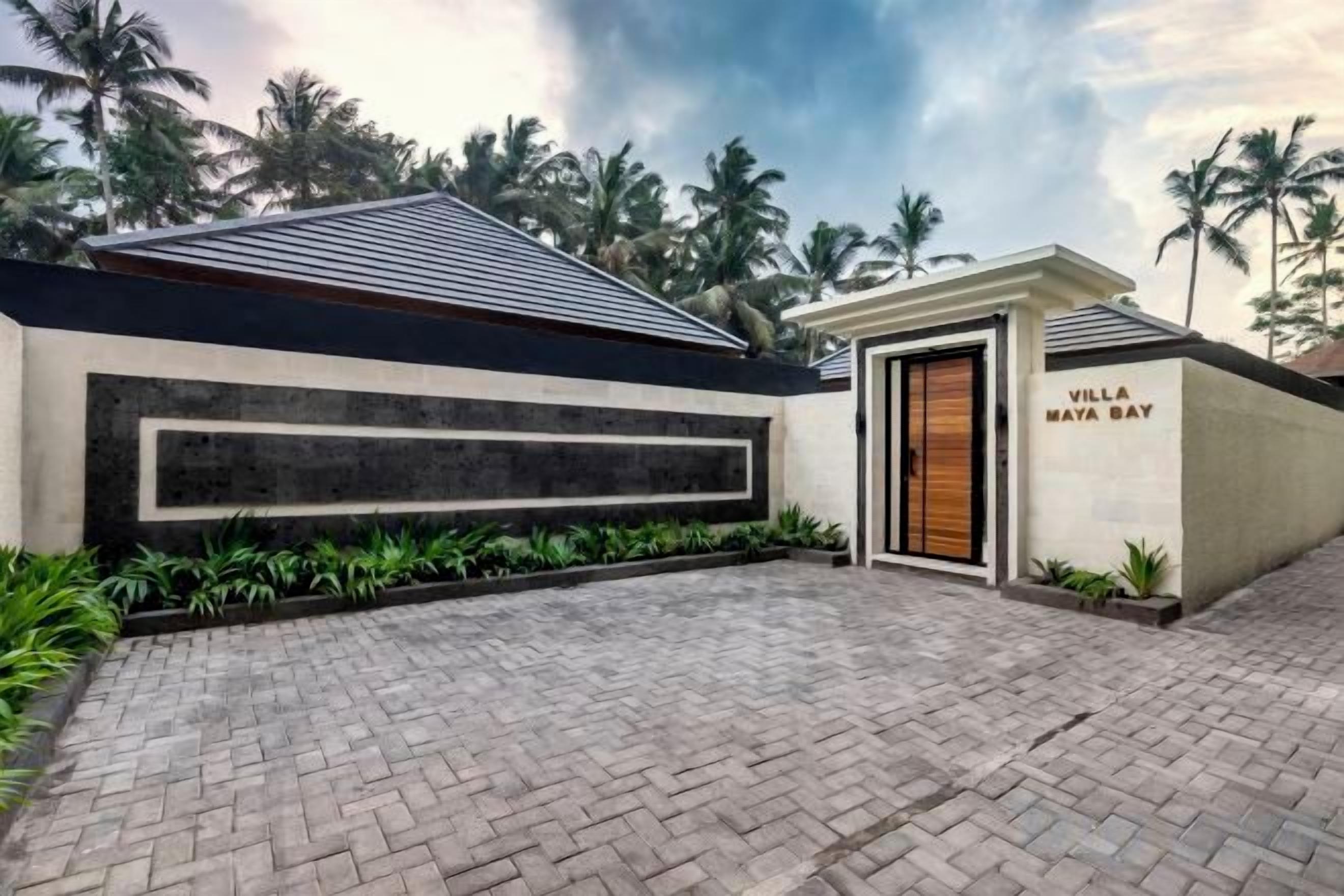 A modern villa with a paved driveway, a garage, and a nameplate reading 'Villa Maya Bay.'