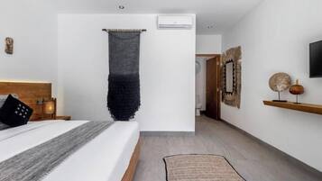 Un dormitorio con cama, mesita de noche, aire acondicionado de pared y un tejido colgante.