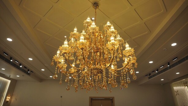 Un gran candelabro ornamentado con múltiples niveles y lámparas colgando del techo alto.