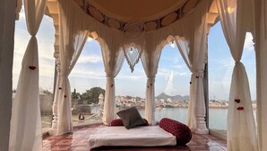 Una habitación con una cama, vistas a una ciudad y una masa de agua.