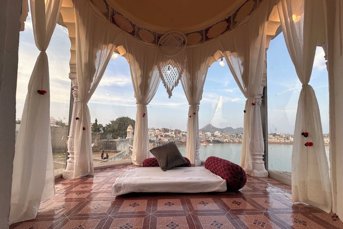 Een kamer met een bed en uitzicht op een stadsgezicht en een wateroppervlak.