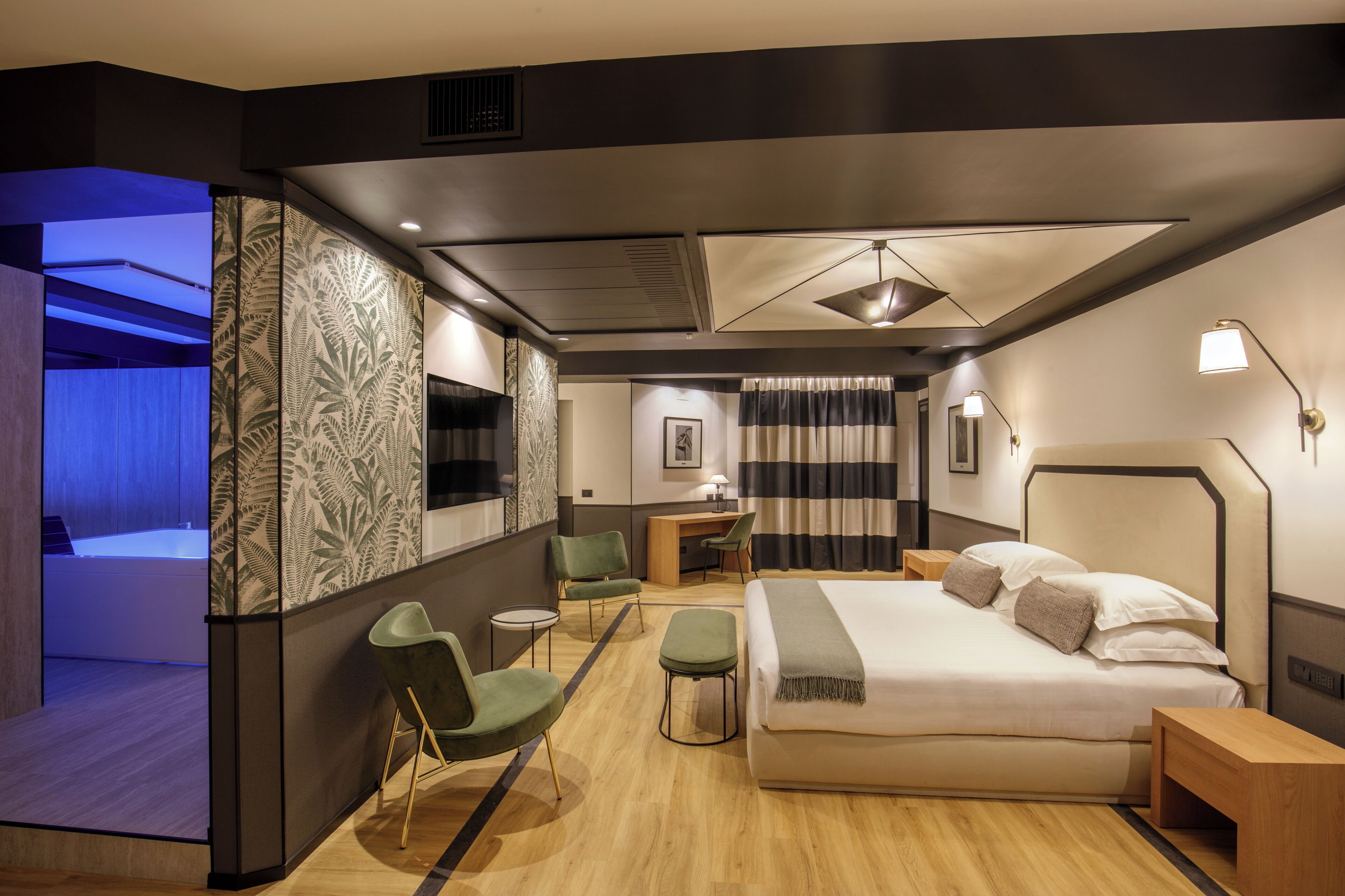 Una habitación de hotel moderna con una cama grande, un escritorio y un área de descanso.