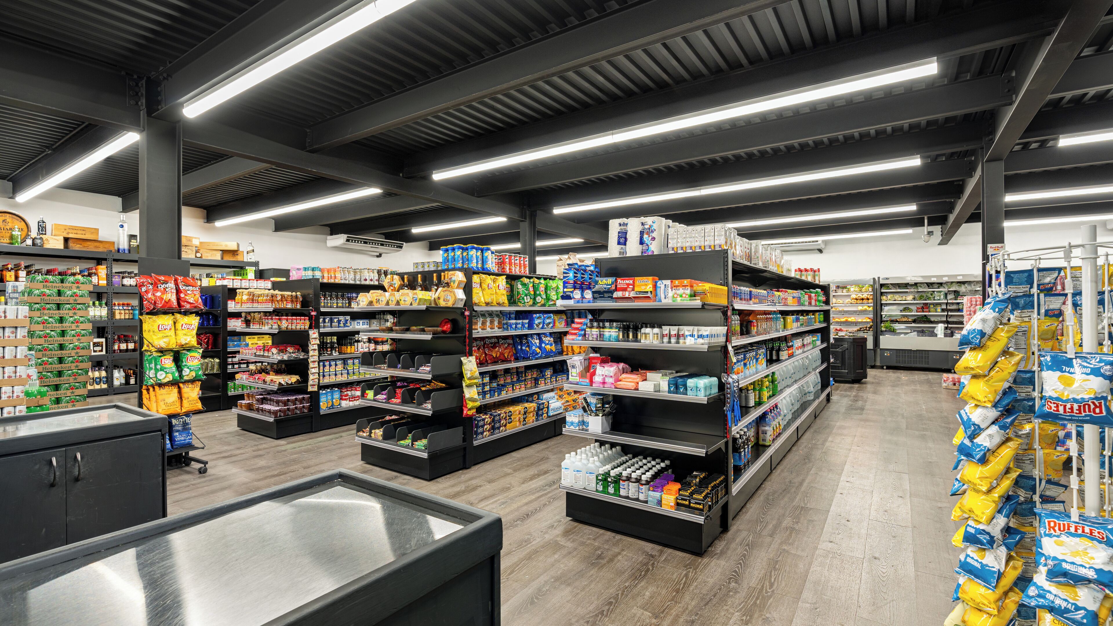 A grocery store interior with wide aisles, stocked shelves, and a refrigerated section.