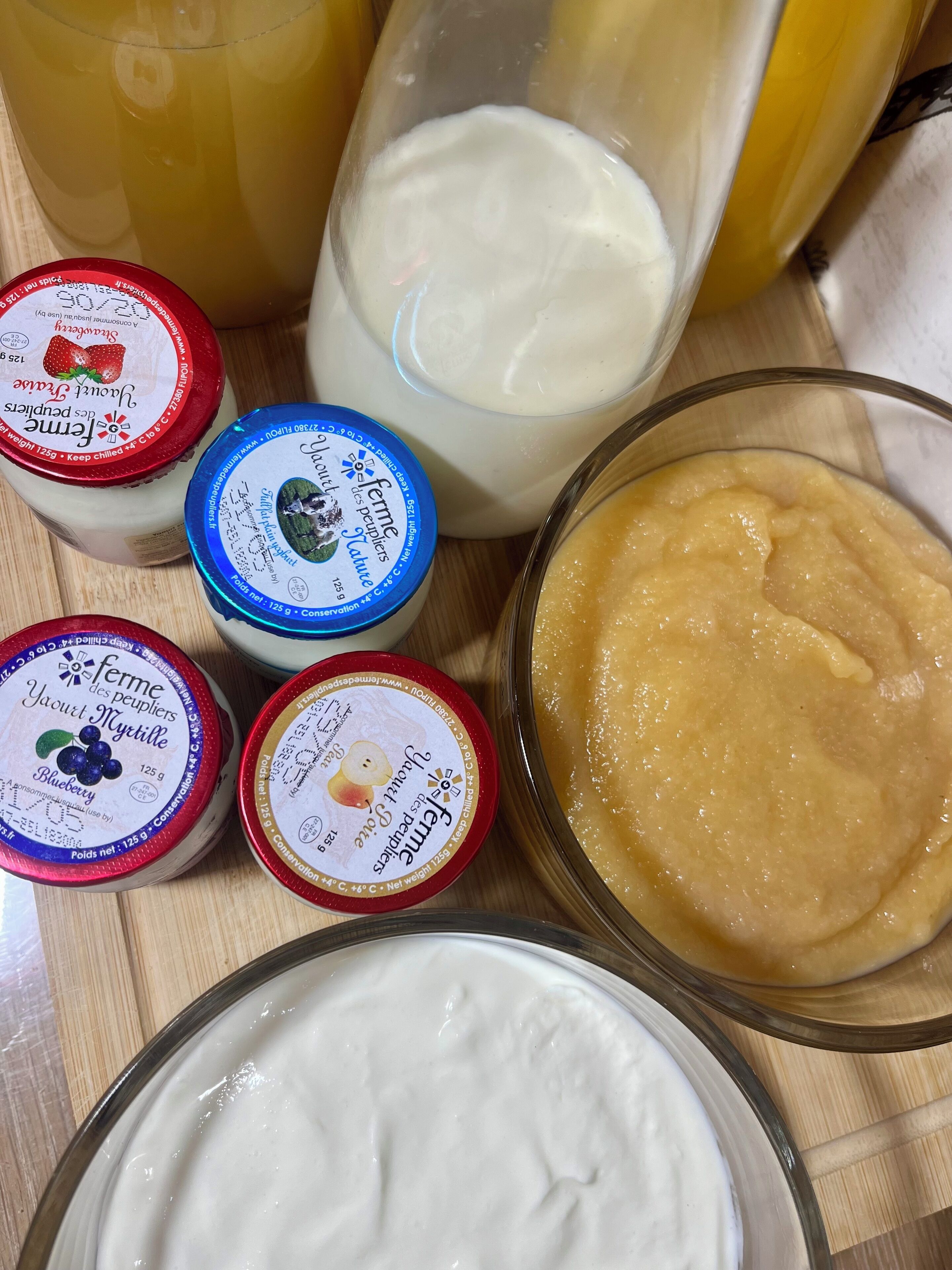 Une variété de produits laitiers, notamment du yaourt et du lait, disposés sur une surface en bois.