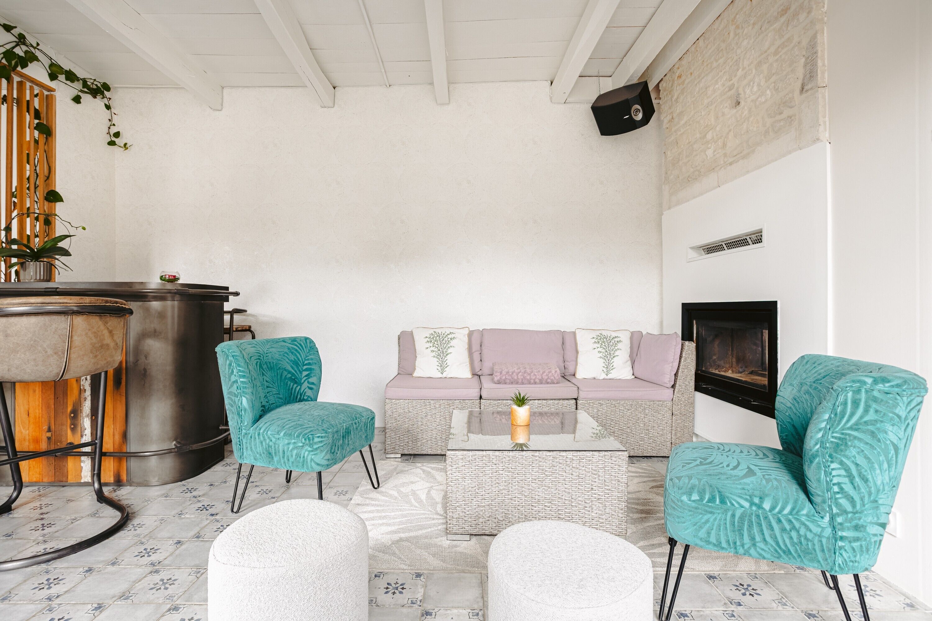 A cozy living area with a sofa, two chairs, a coffee table, a fireplace, and a bar area.
