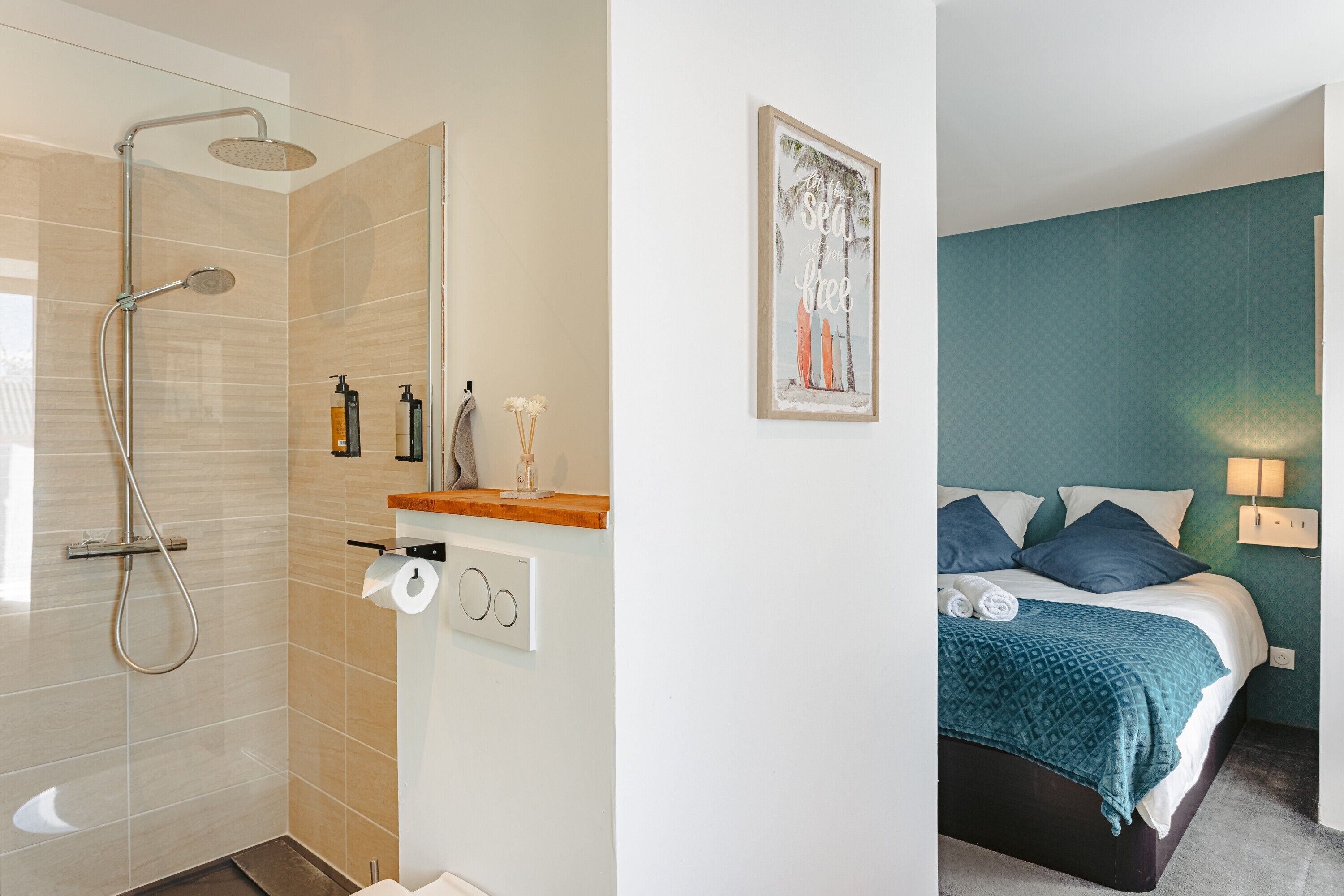 Une salle de bain avec une douche, du papier toilette et une étagère contenant des articles de toilette.