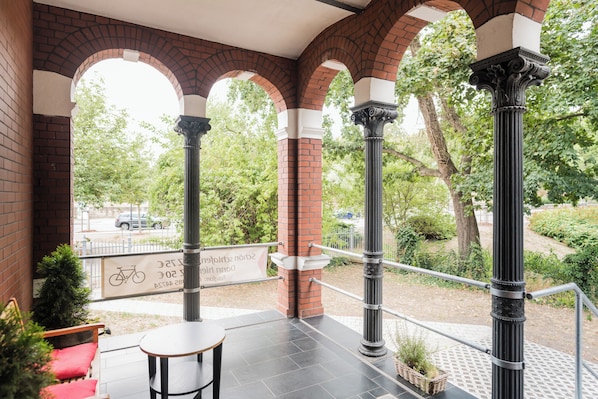 An outdoor patio with brick arches, a metal railing, and a sign indicating a bike rental service.