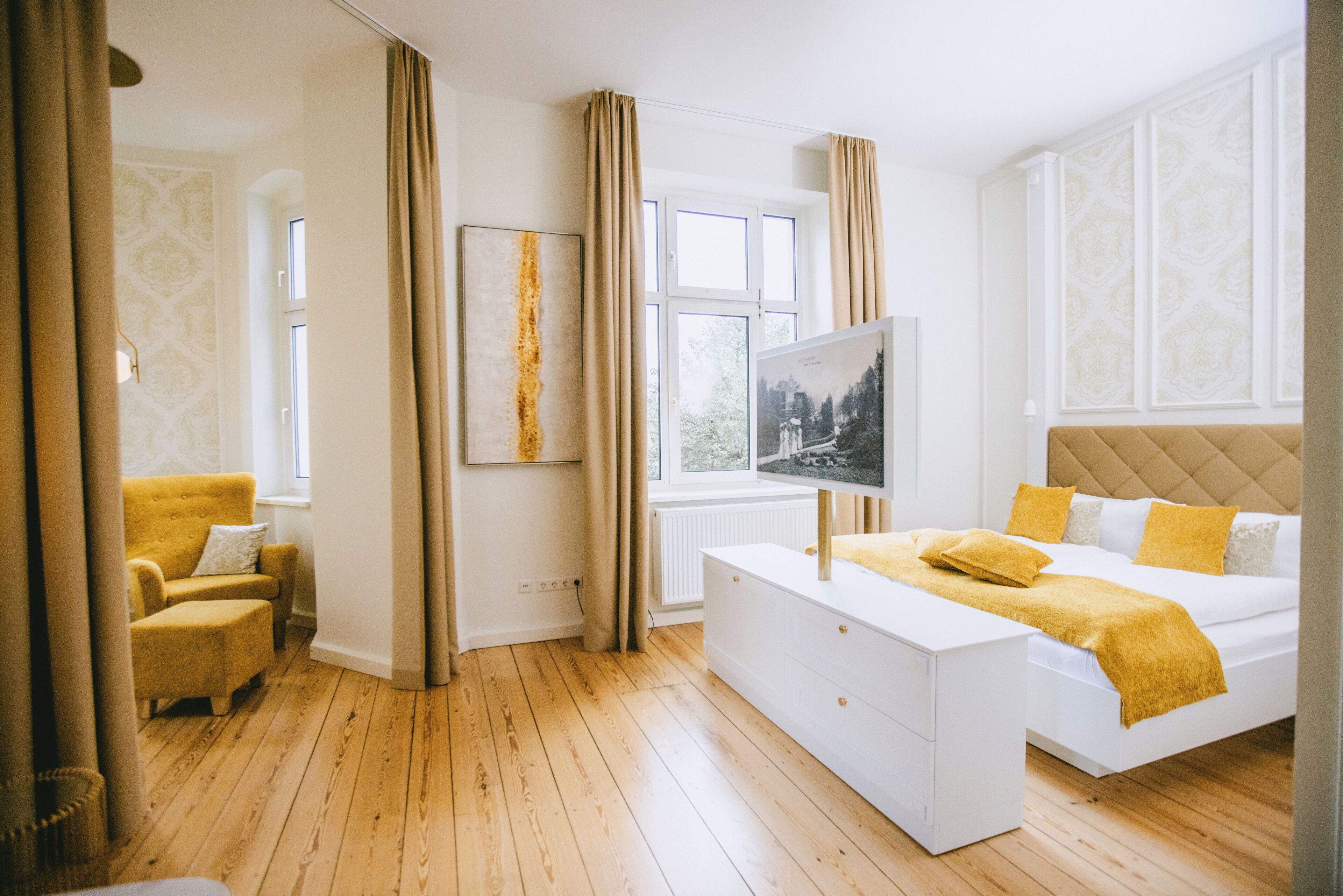 Une chambre d’hôtel avec un lit, un canapé, une télévision et une fenêtre.
