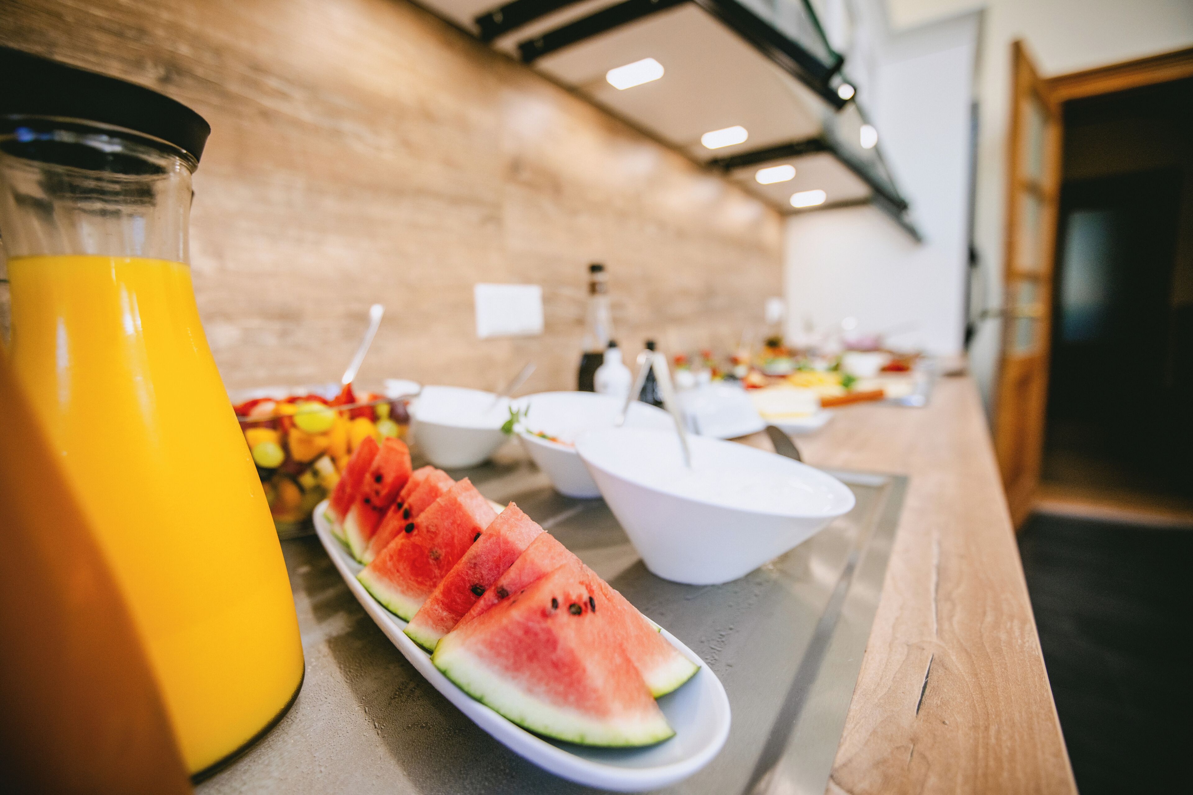 Un buffet proposant une variété de plats et un distributeur de jus.