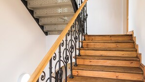A wooden staircase with ornate metal railings and a white wall. - Johanniter Hotel Wittenberg (Lutherstadt Wittenberg)