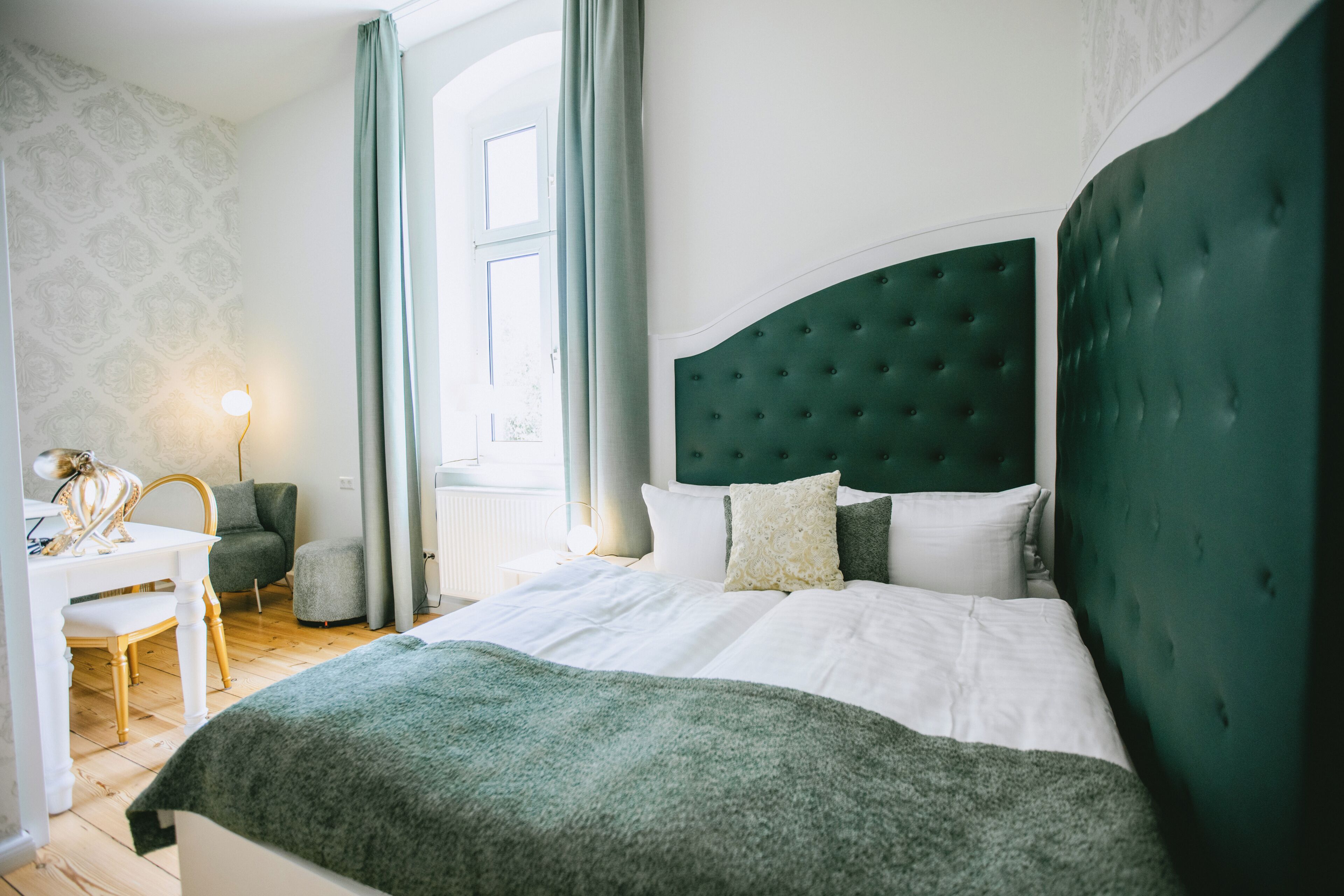Une chambre avec un grand lit, un bureau et une chaise.