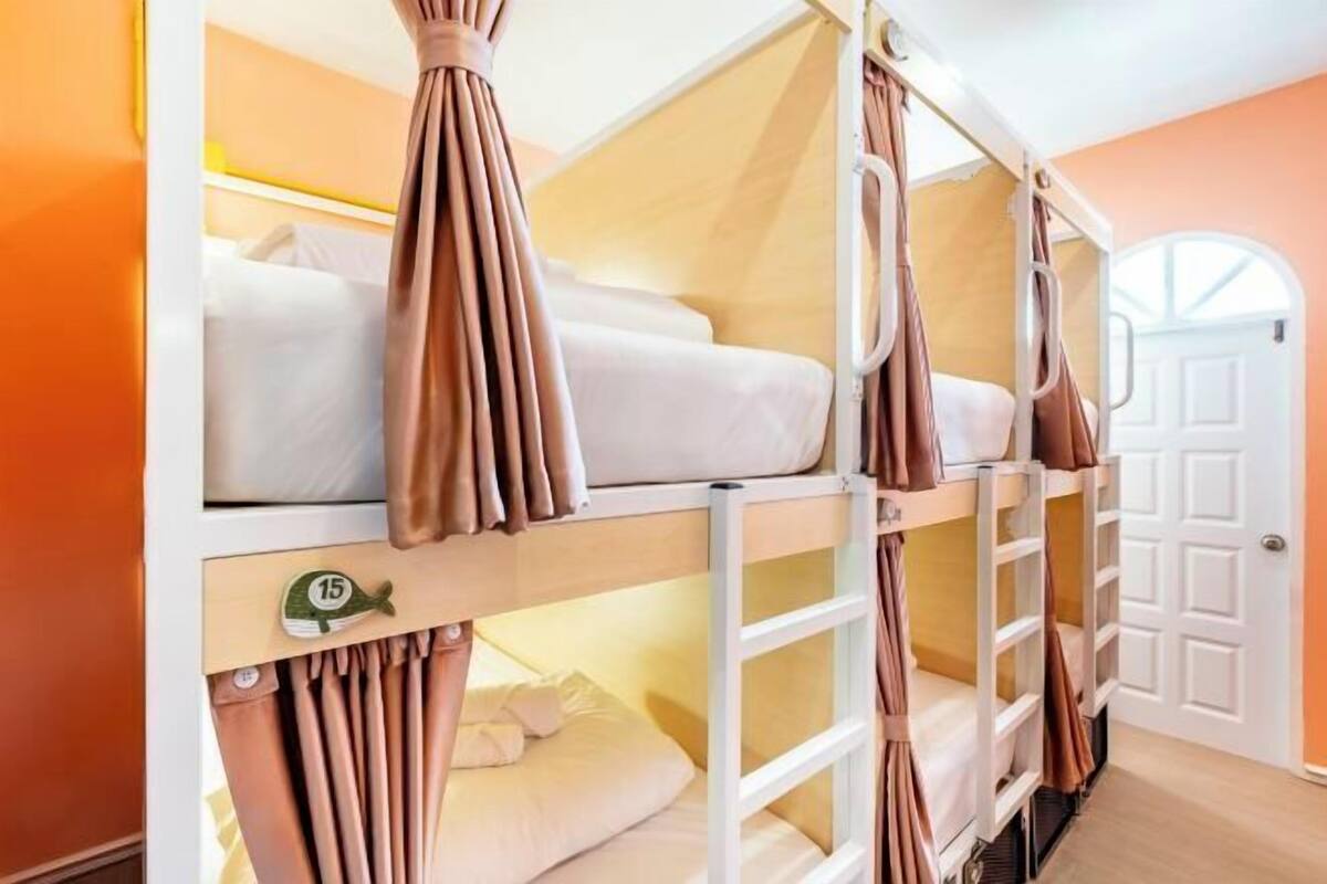 A bunk bed room with a door and a window.