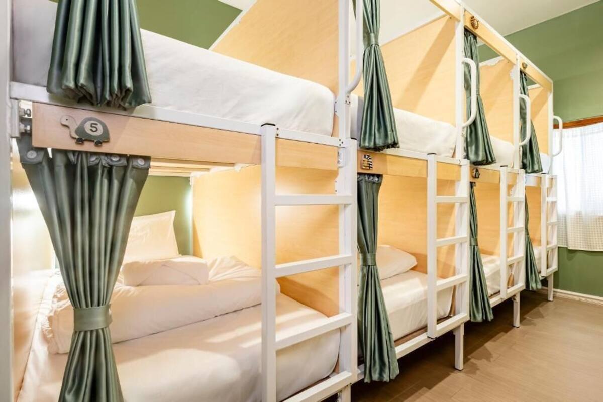 A bunk bed room with curtains, a number '5' sign, and a window with white curtains.