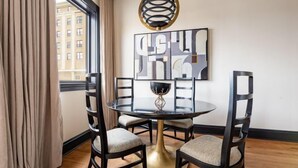 A dining area with a round table, four chairs, and a decorative bowl centerpiece. - 1BR Penthouse Steps to French Quarter The Mayfair (New Orleans)