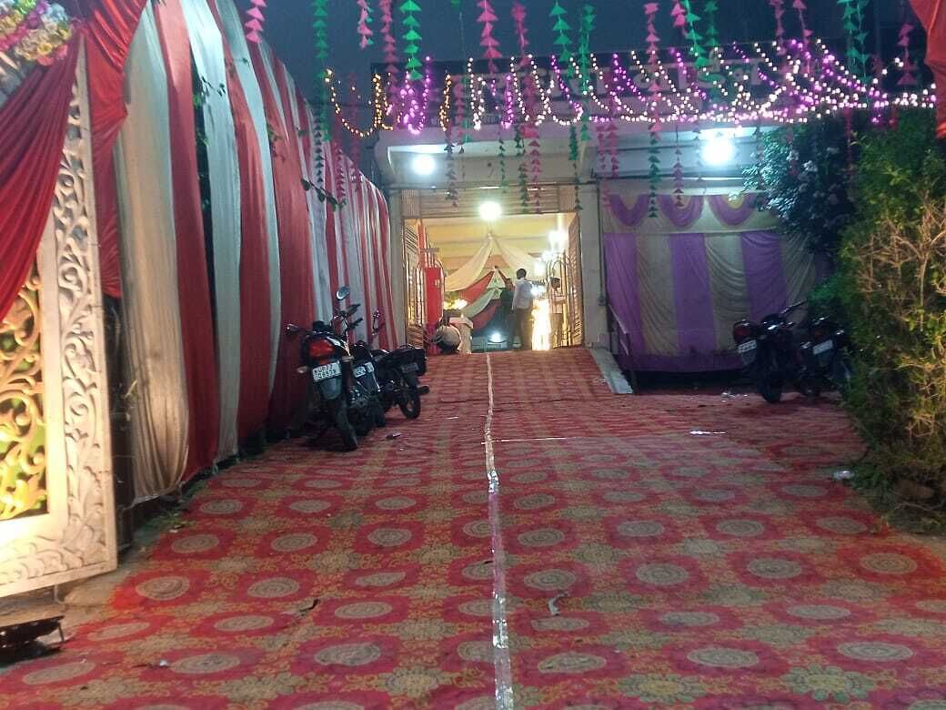 A decorated entrance with patterned carpet, a motorcycle, and a building entrance.