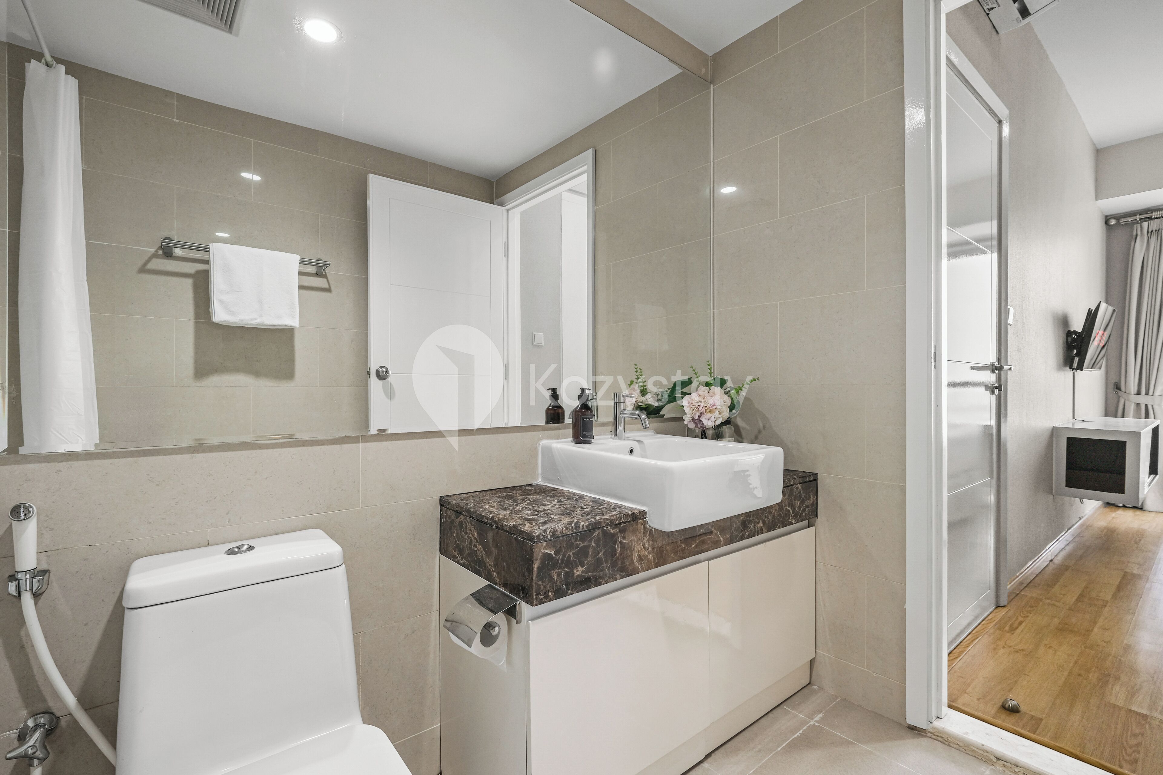 Een moderne badkamer met toilet, wastafel en douche.