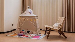 A cozy room with a small tent-like play area, a cushioned chair, and a 'Luck Day' mat. - Yemuqingshan  (Ngawa Autonomous Prefecture)