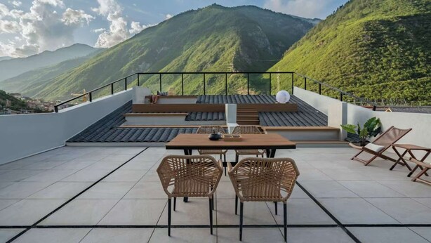 A terrace with a table and chairs, offering a view of green mountains. - Yemuqingshan  (Ngawa Autonomous Prefecture)