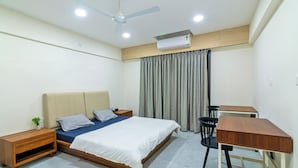 A bedroom with a bed, bedside tables, a desk, and a chair. - Tribe Moro Balewadi  (Paud)