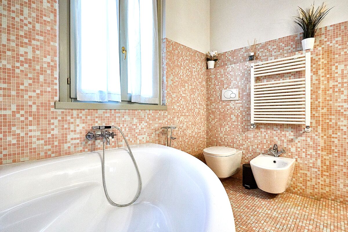 Et badeværelse med et stort badekar, et toilet og en bidét.