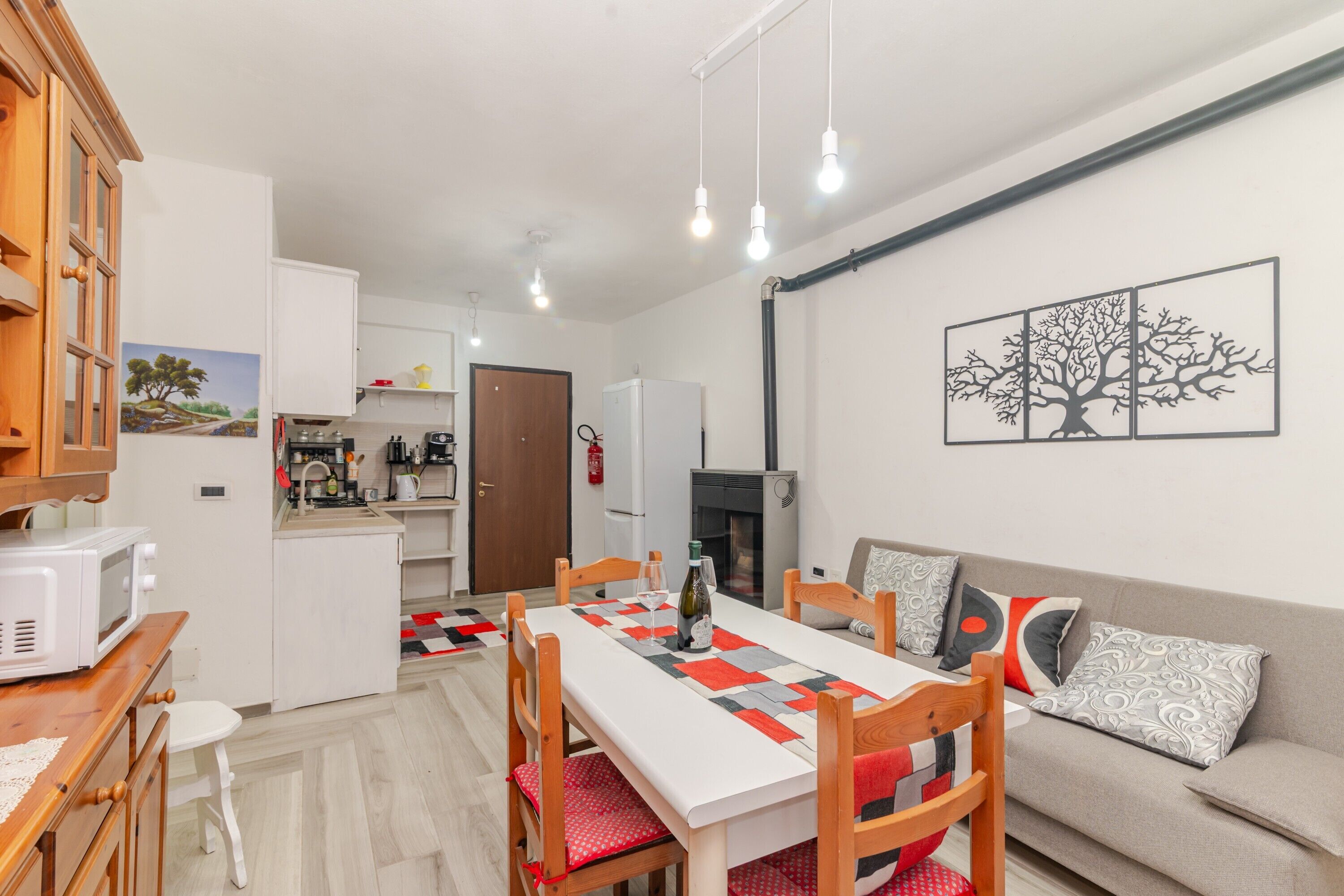 Un espacio habitable compacto con comedor, kitchenette y sofá.