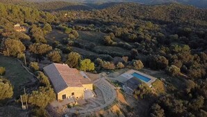An aerial view of a property with a large building, a swimming pool, and surrounding forested hills. - Mimosa Lodge (Quart)