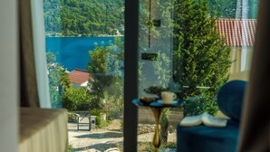 Blick aus einem Fenster auf einen See, im Vordergrund ein Tisch und ein Buch.
