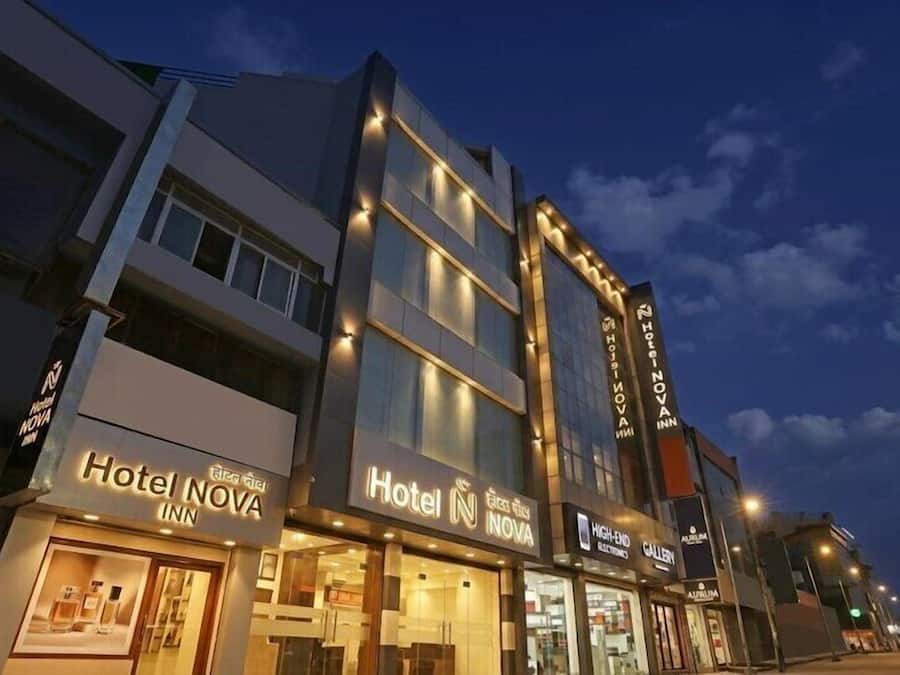 Um hotel de vários andares com sinalização iluminada para o Hotel NOVA e uma galeria sofisticada.