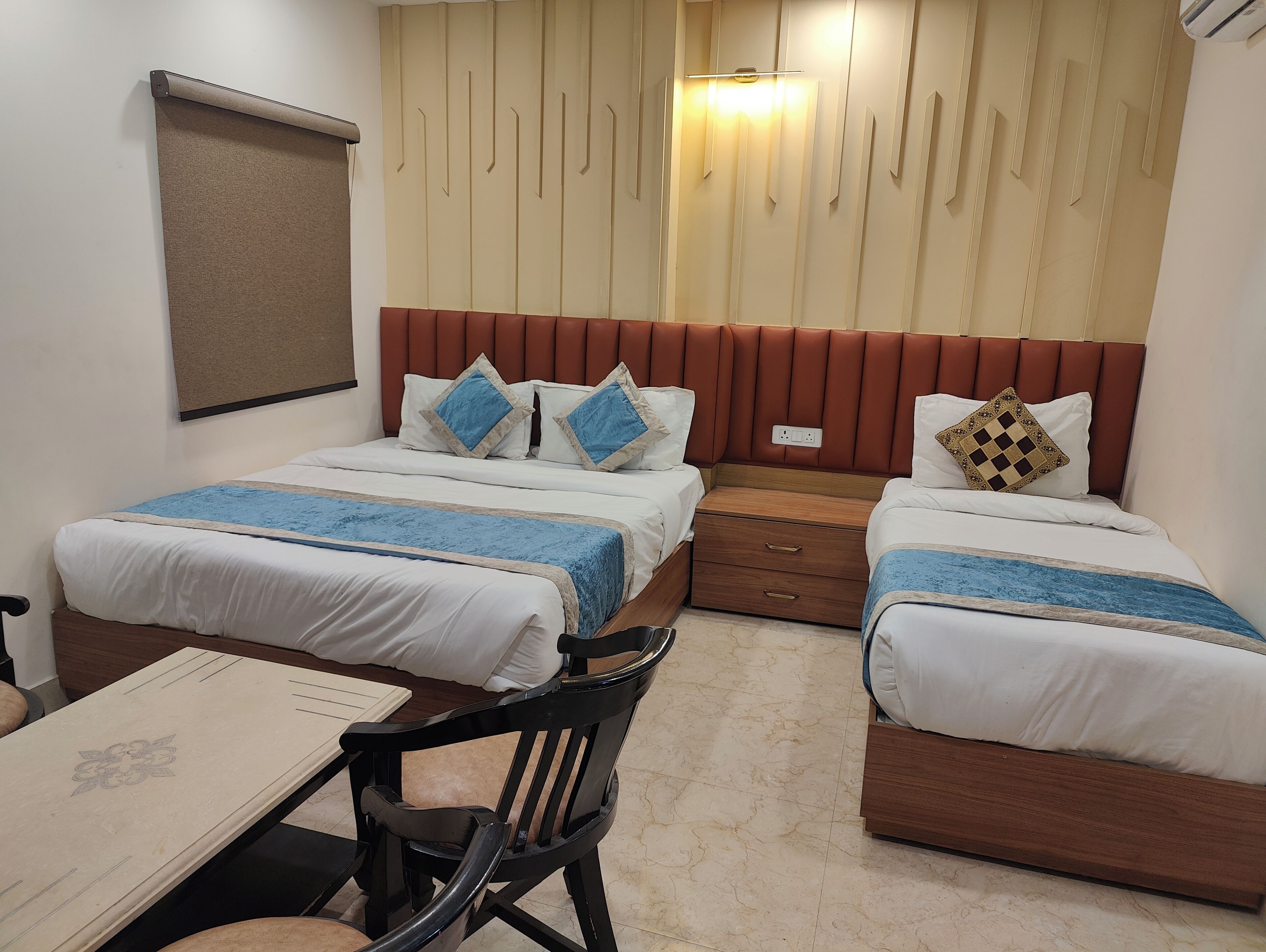 A hotel room with two beds, a desk, and a chair.